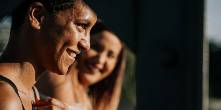 two women are smiling and looking at each other