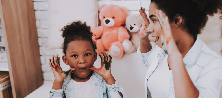 a woman and child are playing with paint on their faces