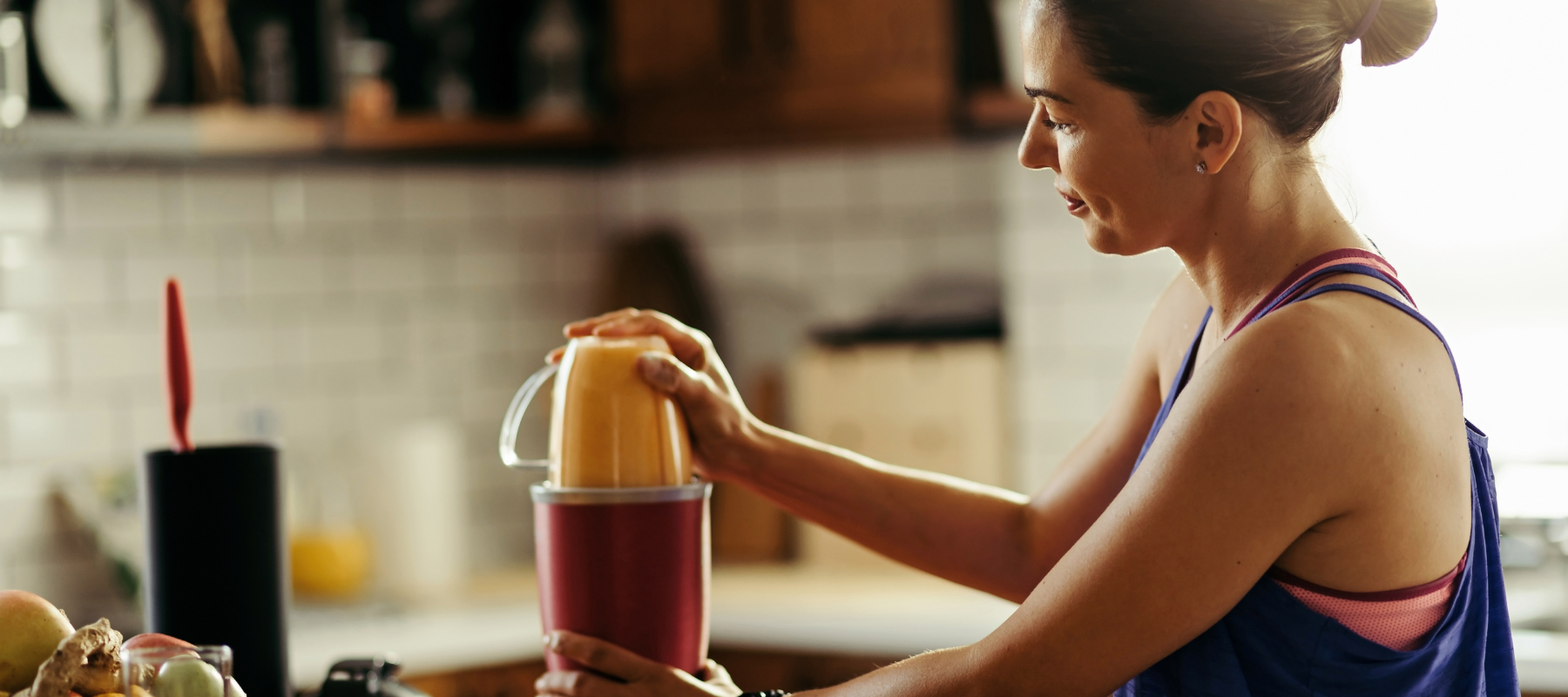 a woman is making a smoothie in a blender