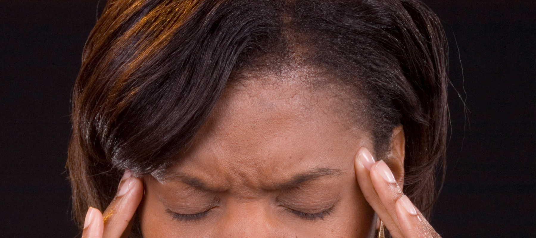 a woman is holding her head with her eyes closed