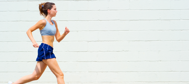 a woman in a blue top and blue shorts is running